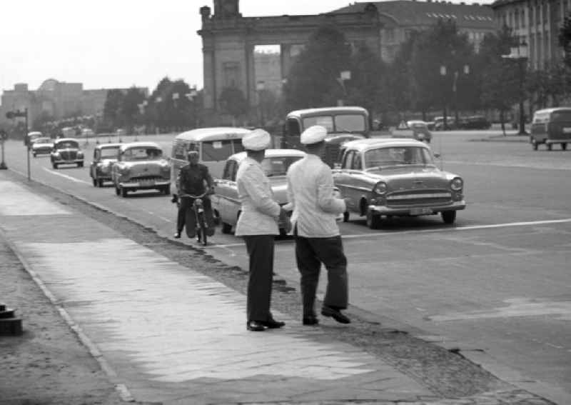 Verkehrspolizisten regeln auf der Straße des 17. Juni in Westberlin den Verkehr. Im Hintergrund Blick auf das Charlottenburger Tor am Ernst-Reuter-Haus. In den 5