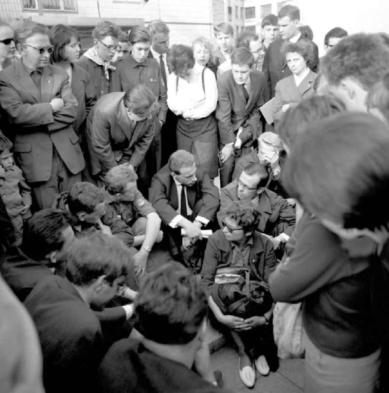 Zu Pfingsten 1964, vom 16.-18. Mai, findet in Berlin das letzte 'Deutschlandtreffen der Jugend für Frieden und Völkerfreundschaft' statt - hier Jugendliche aus Ost und West im Gespräch auf der Karl-Marx-Allee. Ziel der ersten Veranstaltung im Mai 1950 war, die kommunistische Jugend in Ost und West mobil zu machen und der damals in der BRD noch zugelassenen FDJ neue Anhänger zuzuführen. 1951 wurde das Verbot gegen die FDJ in der BRD ausgesprochen. Nach 1964 entsprach eine gesamtdeutsche kommunistische Politik nicht mehr den Zielen der DDR-Regierung. In den 70er und 8