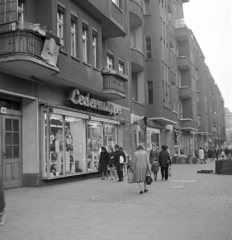 Straßenszene in der Schönhauser Allee in Berlin-Prenzlauer Berg - vereinzelt hängen noch DDR-Fahnen vom 1. Mai an den Balkons und Geschäften. Die Schönhauser Allee gehörte mit ihren vielen Geschäften zu den beliebtesten Einkaufsstraßen des Berliner Osten.