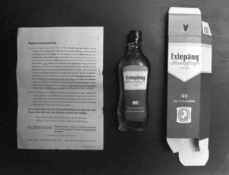 Eine Flasche 'Exlepäng' Haarpflegemittel gegen Haarausfall samt Gebrauchsanweisung und Verpackung.