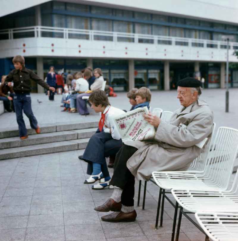 Ein Mann sitzt an den Wasserspielen vor dem Berliner Fernsehturm in Berlin und liest eine Zeitung zum VIII. Schriftstellerkongreß.