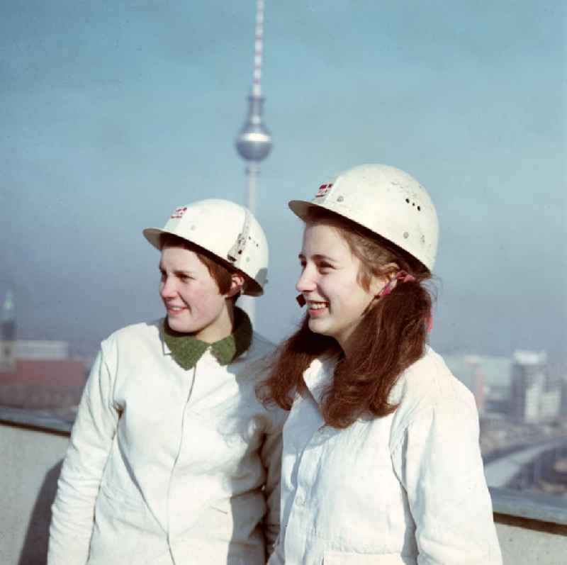 Zwei Mädchen absolvieren ihre Ausbildung im VEB Wohnungsbaukombinat Berlin - hier auf einer Baustelle im Fischerkietz auf der Fischerinsel in Berlins Mitte. Im Hintergrund die Marienkirche (l), der Fernsehturm und die Rathauspassagen. Es war erklärtes Ziel der Gleichstellungspolitik in der DDR, die Gleichberechtigung der Frau auf allen Gebieten des öffentlichen und privaten Lebens zu gewährleisten. Dazu gehörte auch die Förderung der Berufstätigkeit von Frauen in 'typisch männlichen' Berufszweigen.