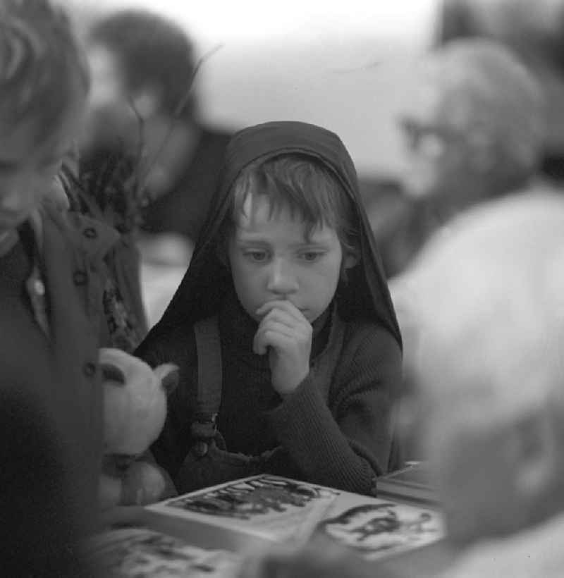 Kinder betrachten ein Buch auf dem Schriftstellerbasar in Berlin.