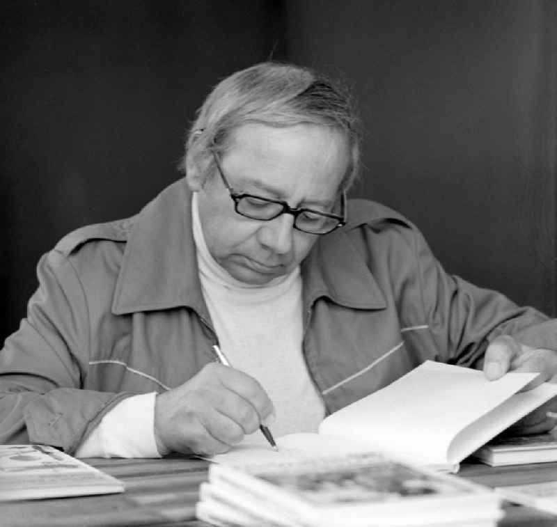 Der Schriftsteller Karl Rezac signiert ein Buch auf dem Schriftstellerbasar in Berlin.