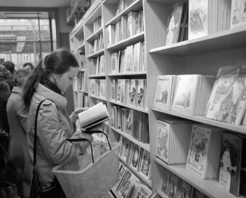 Eine Frau blättert in der Kinderbuchabteilung der Kleist Buchhandlung in Berlin in einem Buch.