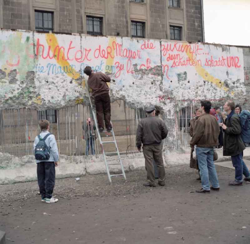 Wallpeckers and souvenir collectors at the Berlin Wall at the Reichstag building in Berlin. As wallpeckers people were popularly known, the edited the Berlin Wall after the Wall fell in 1989 and crushed