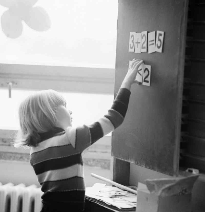 A student stands at the blackboard and solve math problems, in Berlin