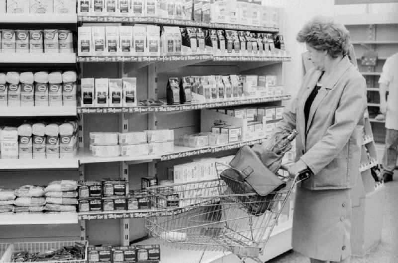 A woman shopping in a department store in Berlin, the former capital of the GDR, the German Democratic Republic. The shelves are filled partly with East products as well with Western products