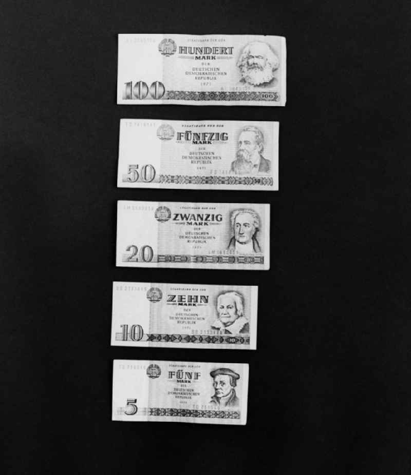 Various banknotes in stacks on the table of a bank employee as legal tender and currency put into circulation by the State Bank in the Mitte district of Berlin, East Berlin in the territory of the former GDR, German Democratic Republic