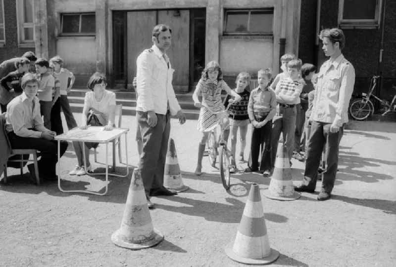 Schoolgirls and schoolboys with the road safety education in the holiday's plays / hoard on the summer holidays in Berlin, the former capital of the GDR, German democratic republic. The holiday's plays were intended mainly for schoolboys first to the fourth class