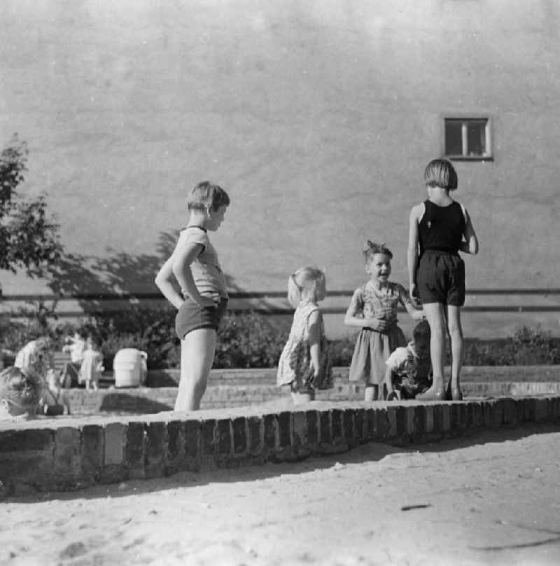 Playing children in a Buddelkasten in Berlin, the former capital of the GDR, German democratic republic