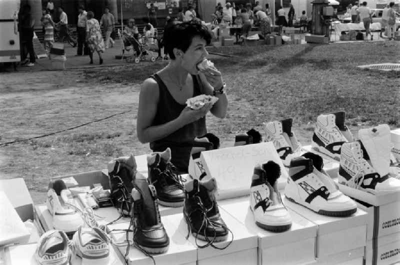 A female street vendor sells at a stall on the Karl-Marx-Allee in Berlin - Friedrichshain sneakers of the brand Commodore