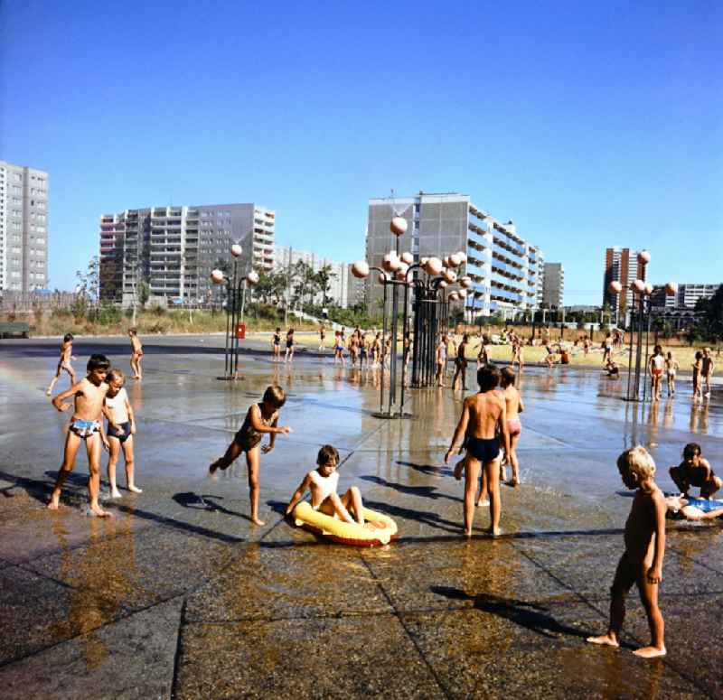 Children play on a water playground in the Marzahn residential area in Berlin Eastberlin on the territory of the former GDR, German Democratic Republic