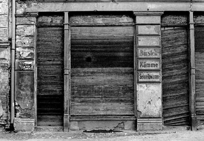 Fading lettering in the entrance area and shop window of a retail store 'Brushes - Combs - Stationery' in the street area of an old residential building facade in the Prenzlauer Berg district of Berlin East Berlin in the area of the former GDR, German Democratic Republic