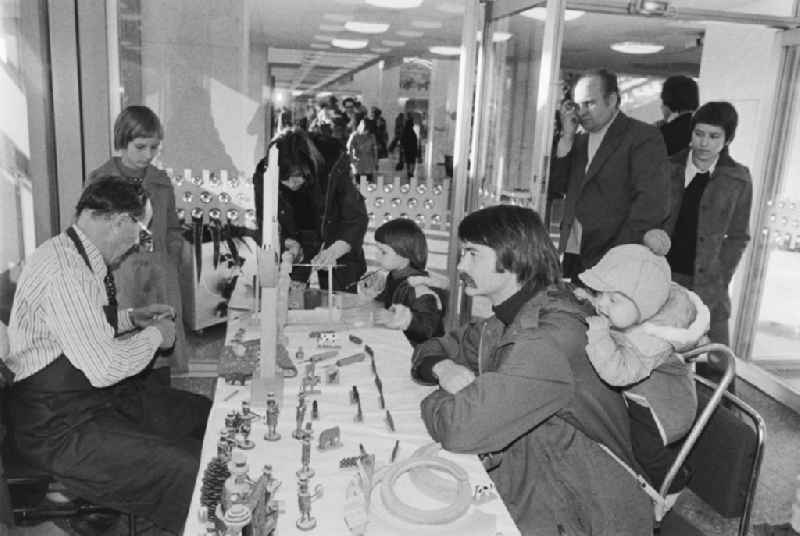 Stand with Erzgebirge wood carving art and visitors on the occasion of the Dresden Cultural Days in the foyer of the Palace of the Republic in the Mitte district of East Berlin in the territory of the former GDR, German Democratic Republic