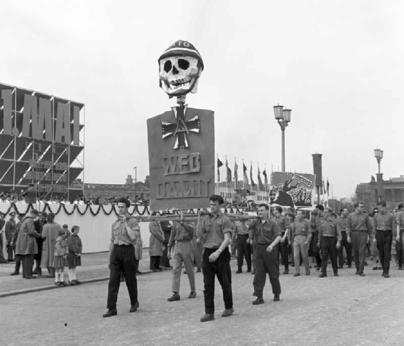 Participants of the May 1st demonstrations with a larger than life skull with steel helmet and Iron Cross 'Get rid of it' on the streets of the city center at Schlossplatz - Marx-Engels-Platz in front of the Berlin Cathedral in the Mitte district of Berlin, East Berlin in the territory of the former GDR, German Democratic Republic