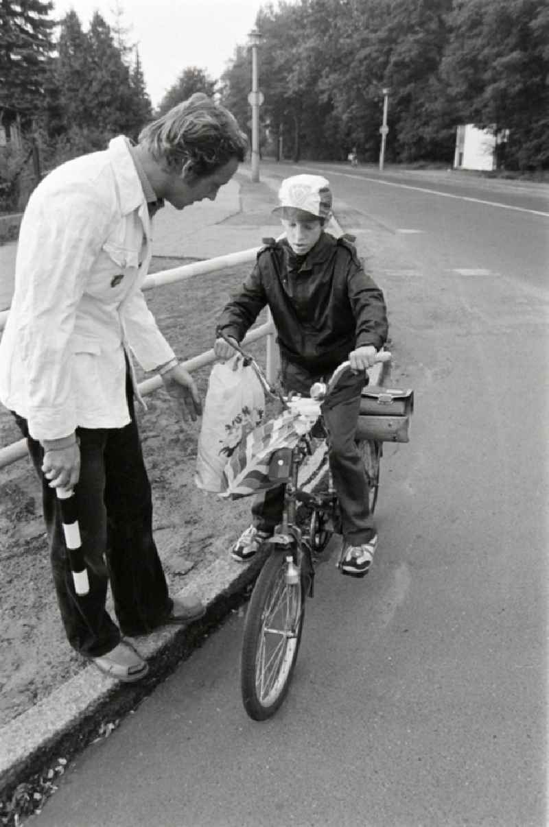 Volunteer traffic assistant of the People's Police checking the road safety of a cyclist in traffic at the intersection at Schulzendorfer Strasse and Waltersdorfer Strasse in the Bohnsdorf district of Berlin, East Berlin in the territory of the former GDR, German Democratic Republic