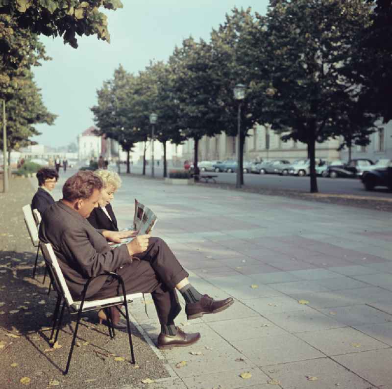 Tourists sit on a bench on the boulevard of the street Unter den Linden in Berlin East Berlin on the territory of the former GDR, German Democratic Republic