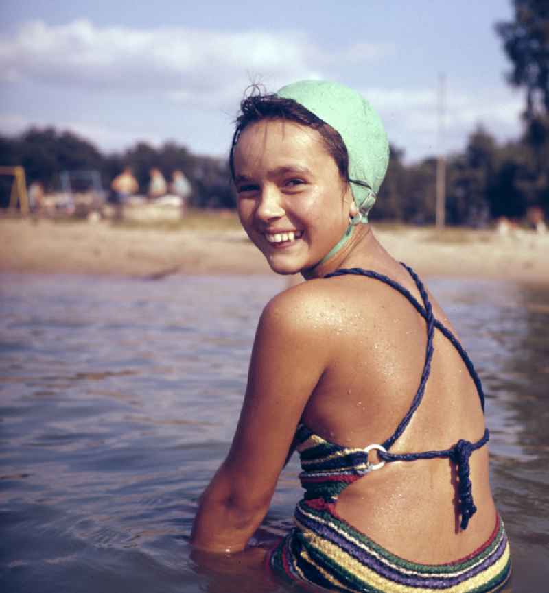 A girl in a swimsuit and swimming cap at a lido on the street Sportpromenade in Berlin East Berlin in the territory of the former GDR, German Democratic Republic