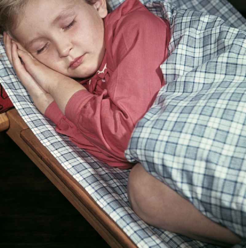 A little girl taking a nap in the kindergarten on Michael-Brueckner-Strasse in the Schoeneweide district of Berlin in the territory of the former GDR, German Democratic Republic