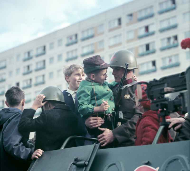 Enthusiastic population forming a guard of honor for the parade drive of military and combat technology 'Armored infantry vehicle SPW BRDM-1' on Lichtenberger Strasse in the district of Friedrichshain in East Berlin in the territory of the former GDR, German Democratic Republic