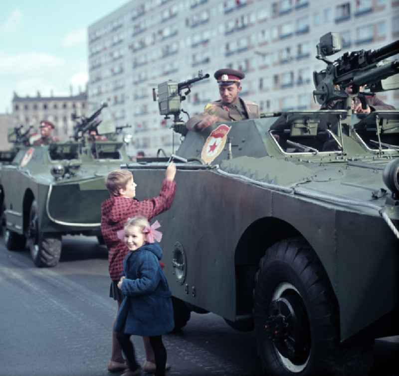 Enthusiastic population forming a guard of honor for the parade drive of military and combat technology 'Armored infantry vehicle SPW BRDM-1' on Lichtenberger Strasse in the district of Friedrichshain in East Berlin in the territory of the former GDR, German Democratic Republic