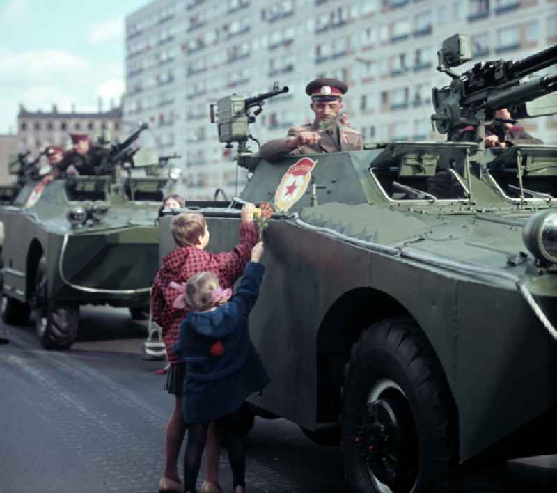 Enthusiastic population forming a guard of honor for the parade drive of military and combat technology 'Armored infantry vehicle SPW BRDM-1' on Lichtenberger Strasse in the district of Friedrichshain in East Berlin in the territory of the former GDR, German Democratic Republic