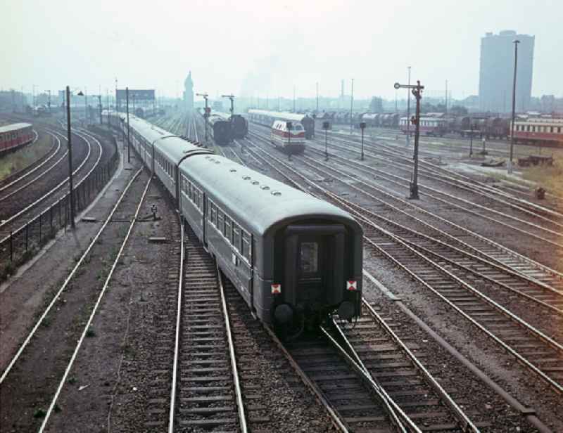 Passenger train in motion on the tracks of the Deutsche Reichsbahn in East Berlin in the territory of the former GDR, German Democratic Republic