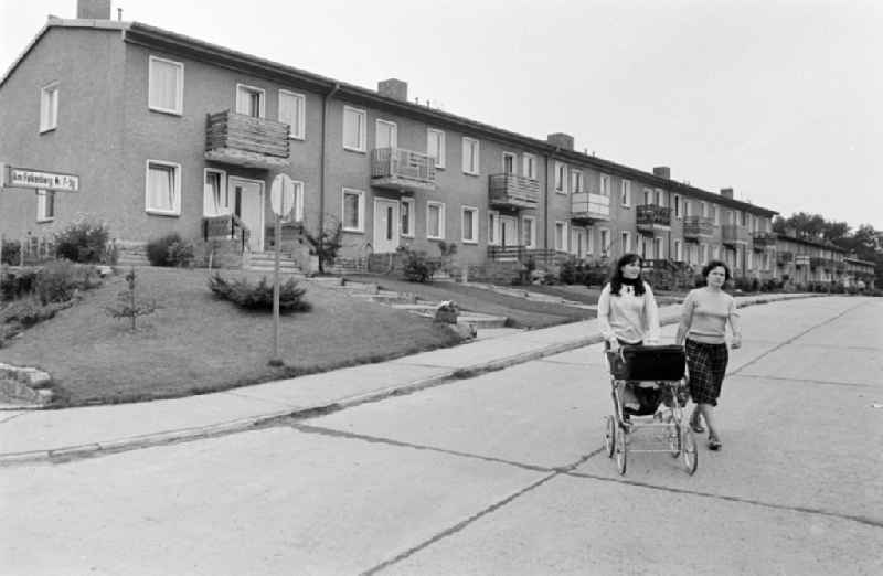 Mother with stroller accompanied in the terraced house complex on the street Am Falkenberg in the district of Gruenau in the district Gruenau in Berlin East Berlin in the territory of the former GDR, German Democratic Republic