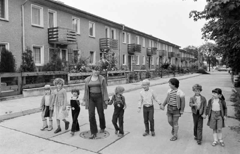 Group of children with a teacher in the terraced house complex taking a walk on Am Falkenberg in the Gruenau district of Berlin, East Berlin in the territory of the former GDR, German Democratic Republic