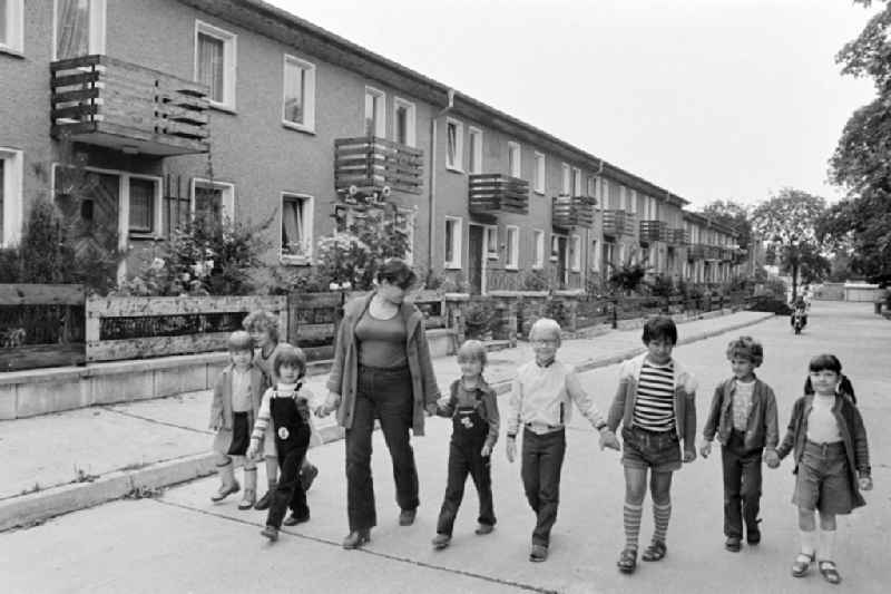 Group of children with a teacher in the terraced house complex taking a walk on Am Falkenberg in the Gruenau district of Berlin, East Berlin in the territory of the former GDR, German Democratic Republic