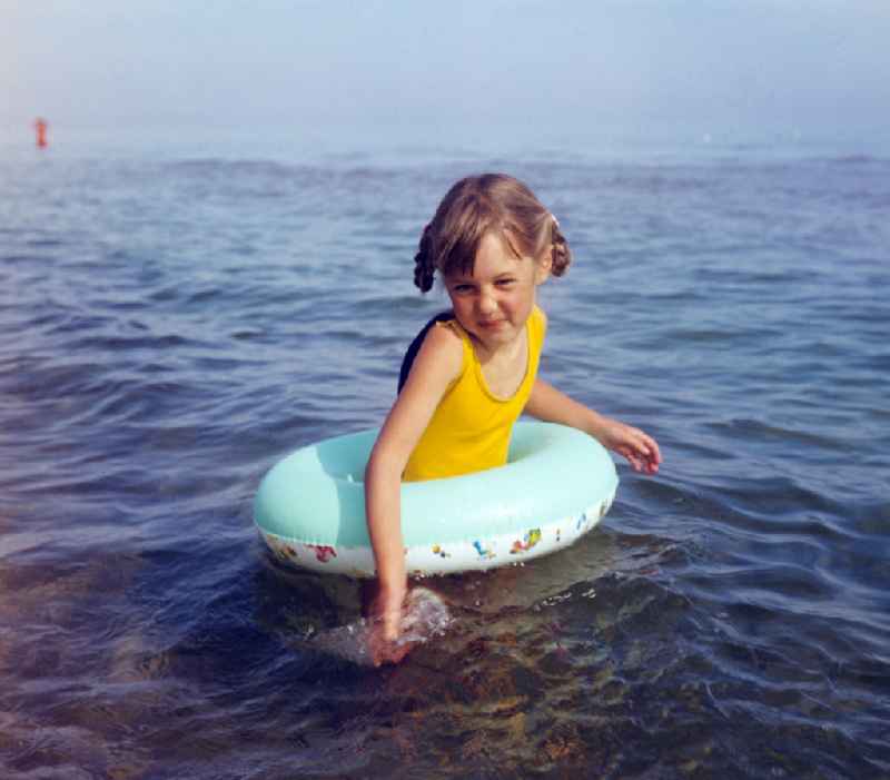 Little girl with swimming ring in the Baltic Sea during a Baltic Sea holiday in Binz, Mecklenburg-Vorpommern in the area of the former GDR, German Democratic Republic