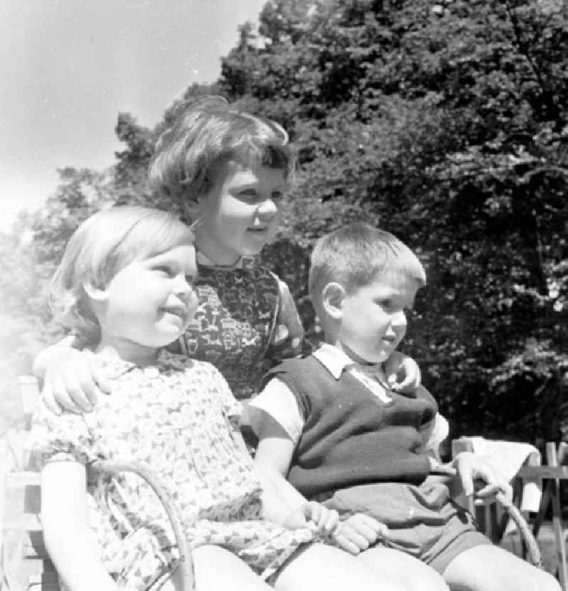 Kinder / Kleinkinder sitzen zusammen in Karussell auf Kindergarten-Spielplatz.