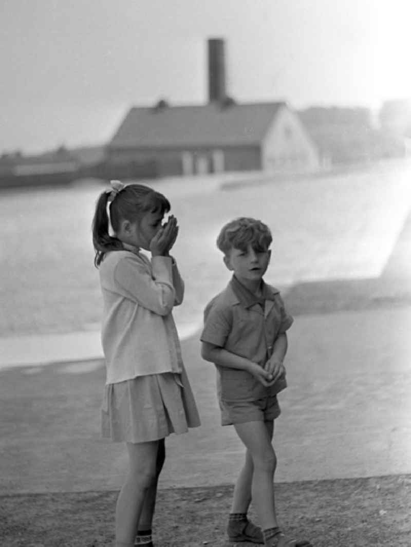 Zwei Kinder bei einer Besichtigung des ehemaligen Konzentrationslagers Buchenwald, das 1958 als Nationale Mahn- und Gedenkstätte eingeweiht worden war. Im Hintergrund das Krematorium.