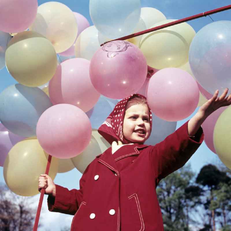 Girl with balloons in a stroller in Coswig, Saxony in the territory of the former GDR, German Democratic Republic