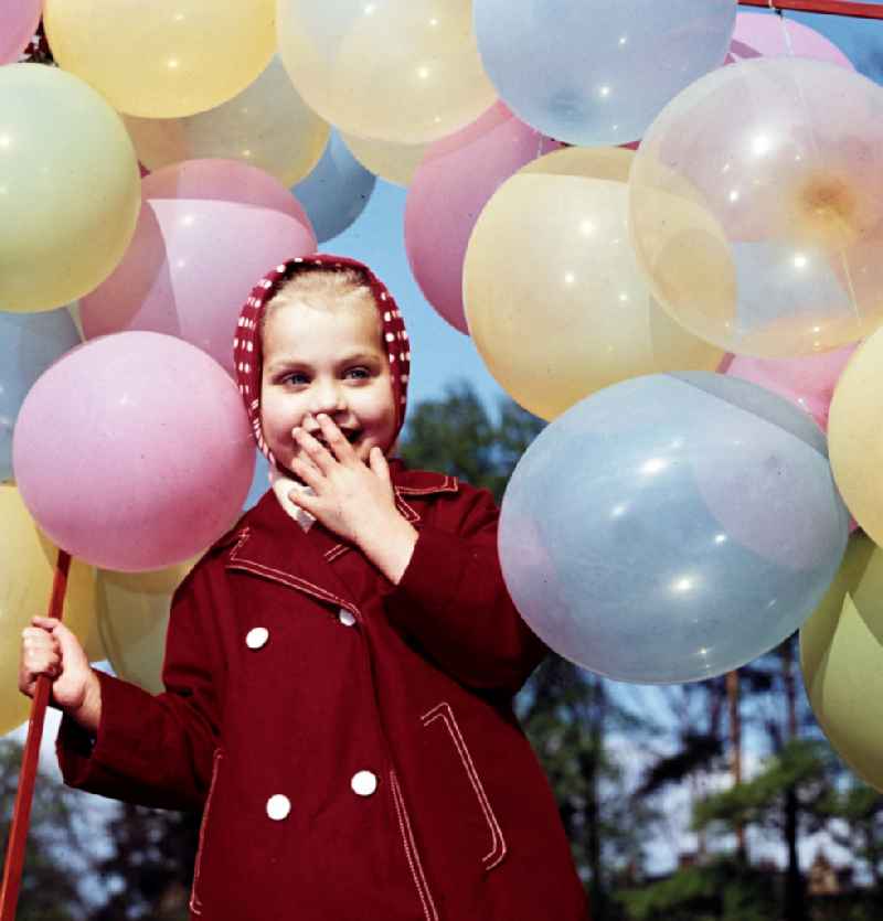 Girl with balloons in a stroller in Coswig, Saxony in the territory of the former GDR, German Democratic Republic