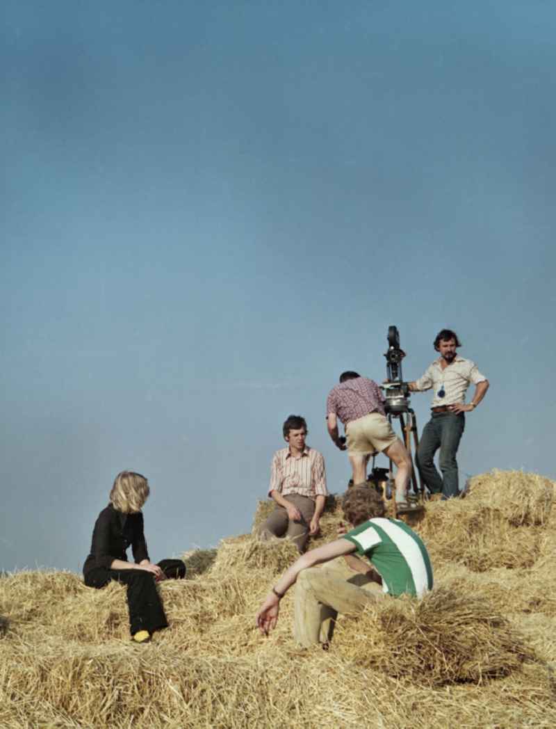 Scene shot from the film and television production 'Portrait of a Center' in Crostwitz, Saxony in the area of the former GDR, German Democratic Republic. The film crew uses stacked straw bales as an elevated vantage point and sets up the camera on a tripod