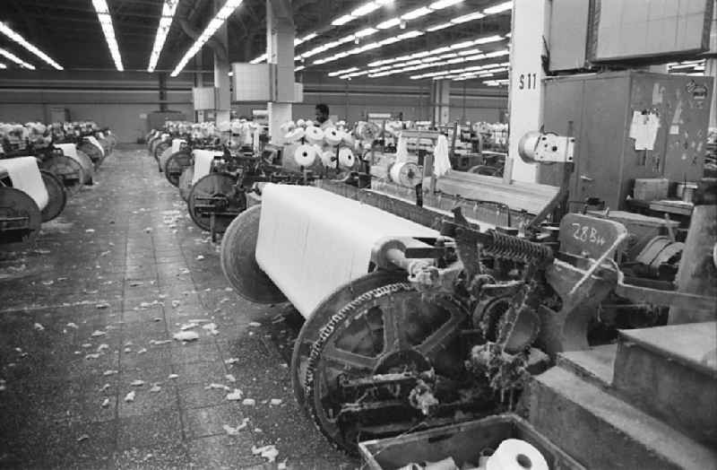 Men at work and factory equipment in the workshop with loom machines in the VEB Lautex spinning mill in Ebersbach in GDR