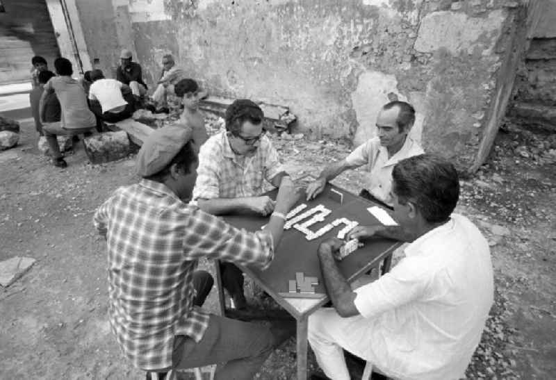 Männer beim Dominospiel in der Nähe des Plaza Vieja in Havanna. Domino ist das 'Nationalspiel' der Kubaner und wird am liebsten am Wochenende, nach getaner Arbeit und am besten mitten auf dem Gehweg gespielt.