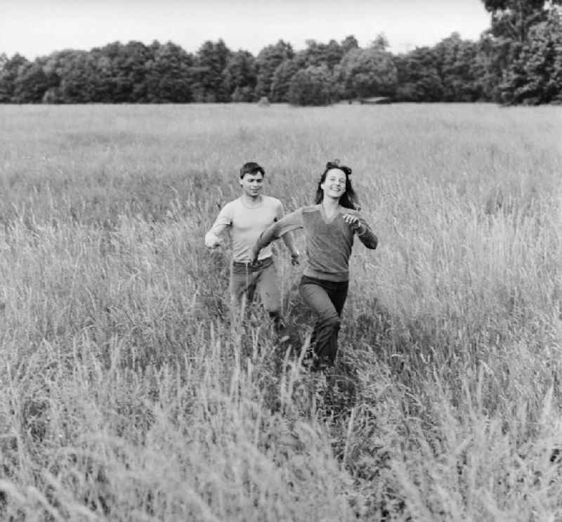 Young couple running through a meadow in Hohen Neuendorf in Brandenburg today