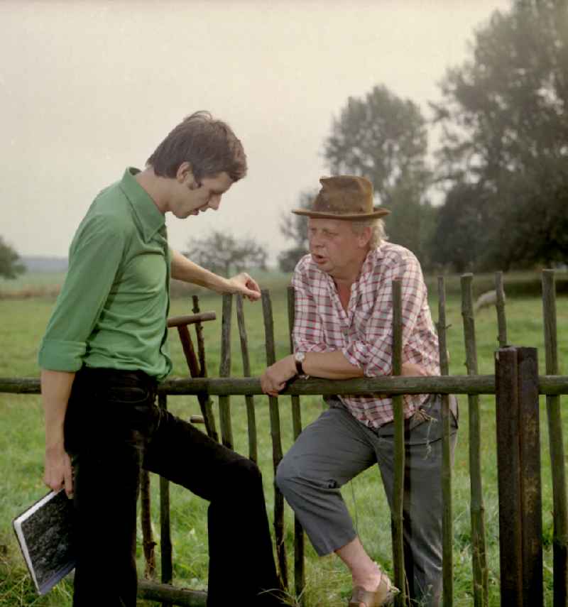 Scene from the film and television production 'Portrait of a Center' on the main street in Horka, Saxony in the area of the former GDR, German Democratic Republic. The director Konrad Herrmann in conversation with the Sorbian children's book author Jan Worner