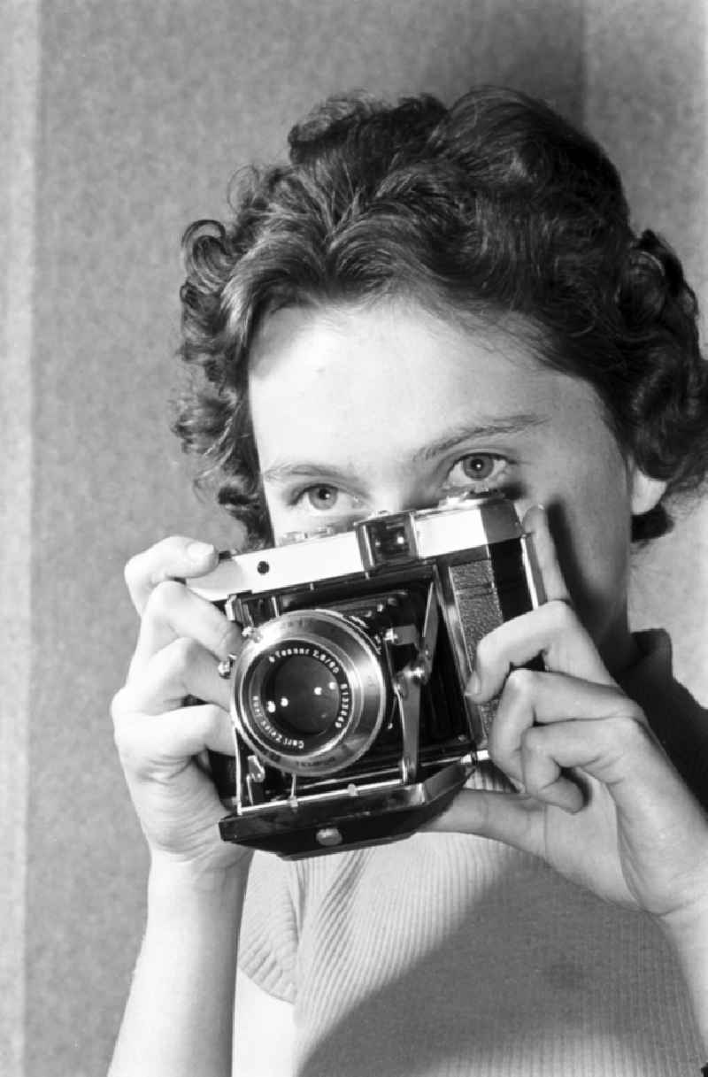 Woman with a camera of the type ' Tempor ' from the VEB Carl Zeiss Jena in Jena, Thuringia in the area of the former GDR, German Democratic Republic