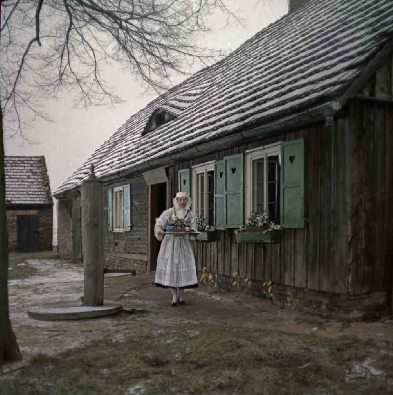 Scene from the film and television production 'Continent Hope' with the actress Majka Kowarjec in Sorbian costume as a mother in front of an old farm in Kreba-Neudorf, Saxony in the area of the former GDR, German Democratic Republic