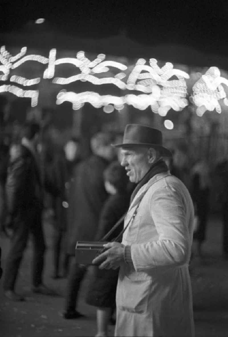 Ein Losverkäufer verkauft mit seinem 'Bauchladen' Lose auf dem Leipziger Weihnachtsmarkt.