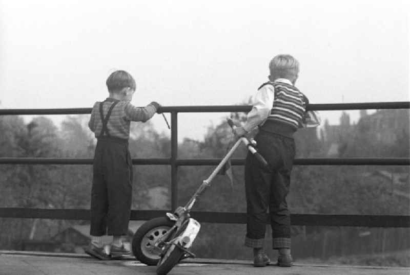 Zwei Jungen stehen auf einer Brücke in Leipzig und schauen in die Tiefe.