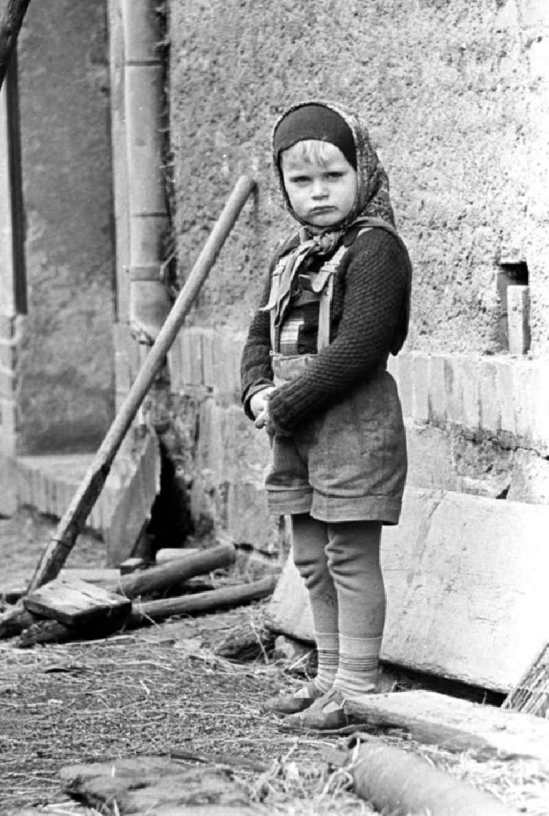 Mit dem Kopftuch von Mutti, der Lederhose des großen Bruders und der selbstgestrickten Jacke von Oma ist dieses Mädchen gut geschützt gegen die aufkommende Kälte des Spätherbstes.