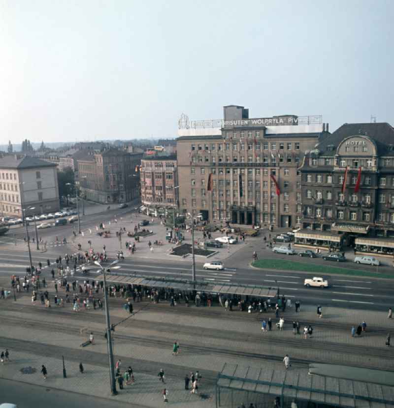 Straßenszene am Tröndlinring in Leipzig mit dem Ring-Messehaus und dem Hotel International. Am Messehaus wirbt für Dederon, Grisuten, Wolpryla und Piviacid geworben.