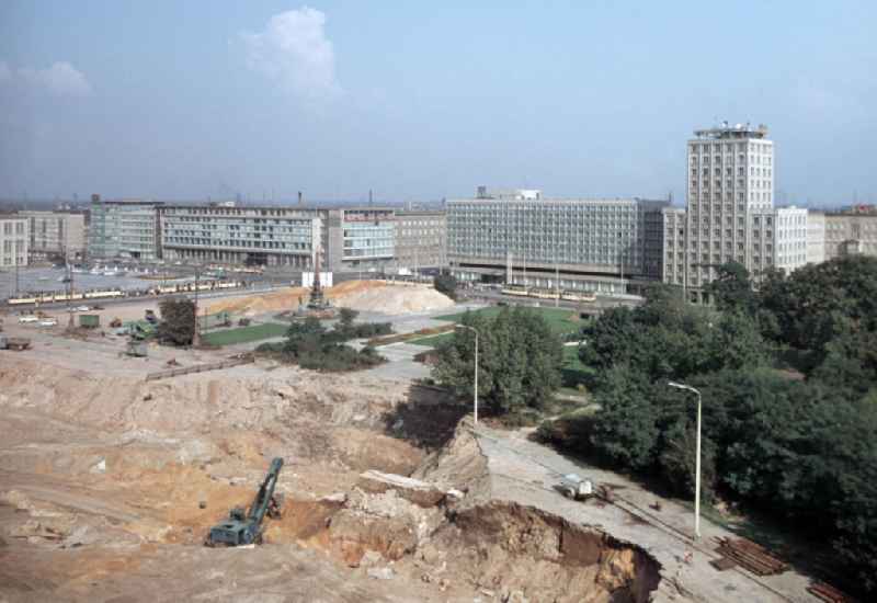 Blick auf die Baustelle für den Neubau der Karl-Marx-Universität in Leipzig. Zuvor war das im Zweiten Weltkrieg teilbeschädigte historische Universitätsgebäude Augusteum (zusammen mit der unversehrten Paulinerkirche) gesprengt worden, um Platz für die Neubebauung zu schaffen. Im Hintergrund der Mendebrunnen (M.) und die Bauten am Augustusplatz und Georgiring.