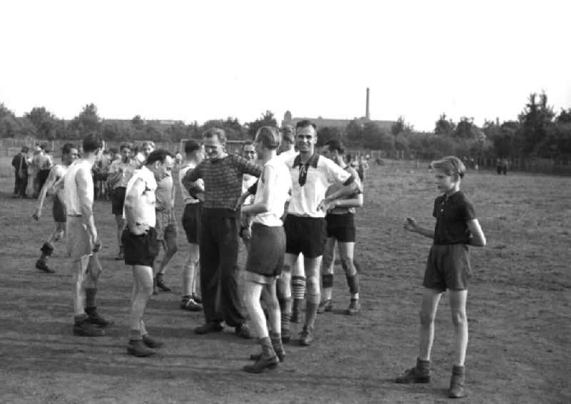 Gruppe von Männern und ein Junge im Sportdress / sportlicher Kleidung auf einem Rasenplatz nach einer Sportveranstaltung. Bestmögliche Qualität nach Vorlage!