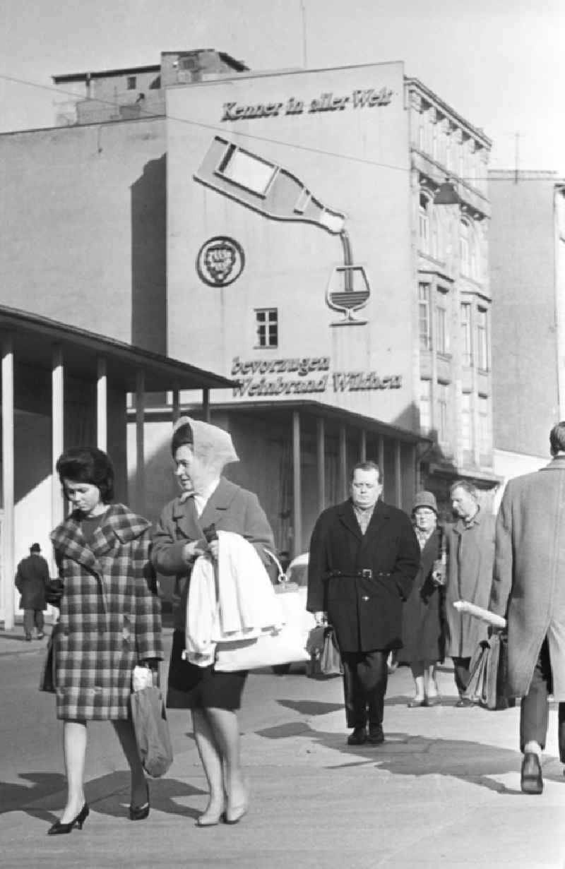 Werbung an einer Hausfassade in der Innenstadt von Leipzig. Der Hersteller Wilthen wirbt für Weinbrand. Auf dem Bürgesteig mehrere Passanten, darunter zwei Frauen im damals typischen 196